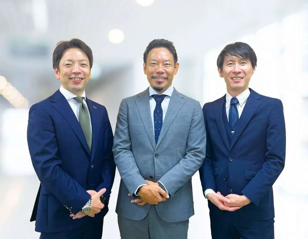 3人の社員がにこやかに微笑んでいる写真